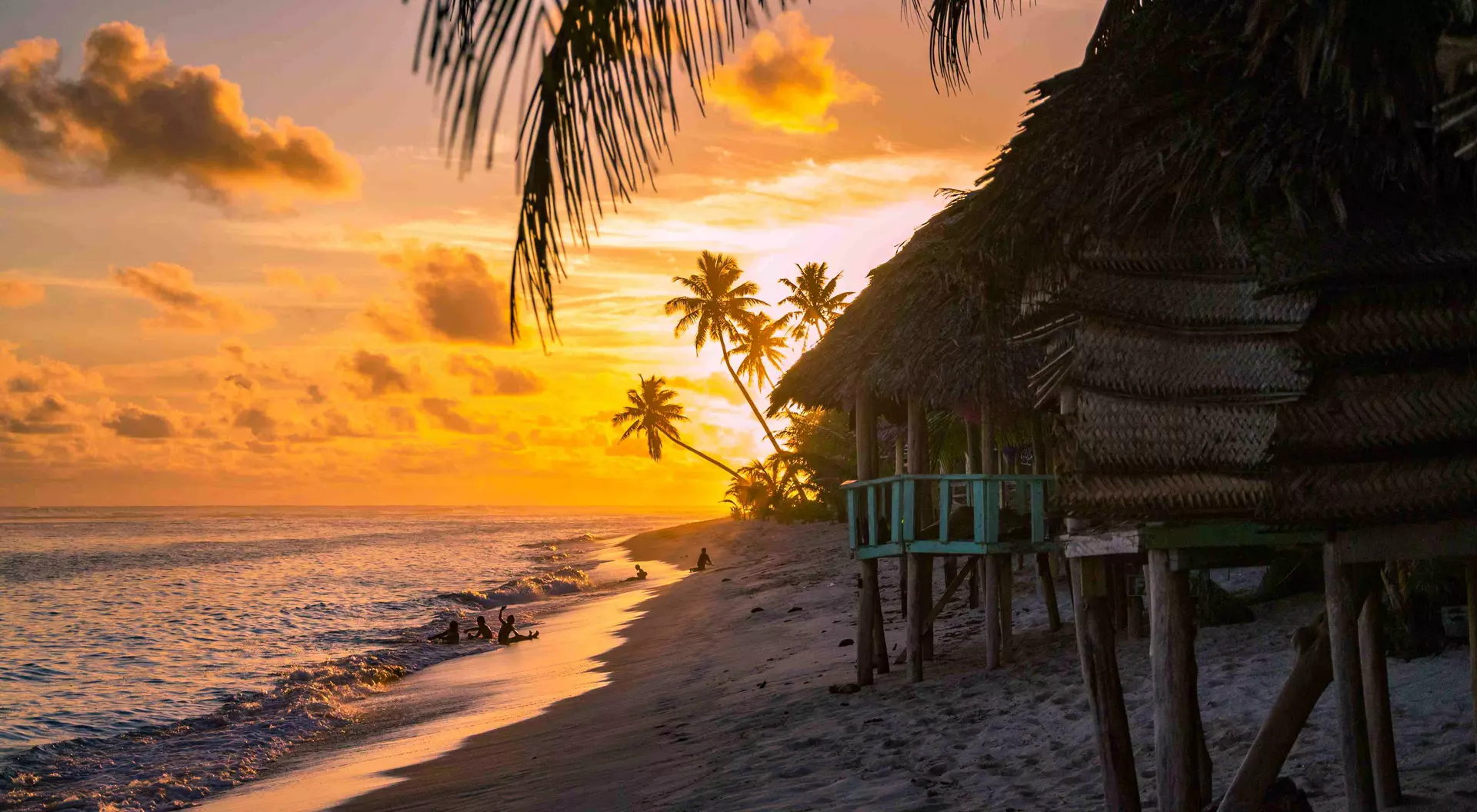 beach bungalows during sunset with ocean calmly lapping the sand