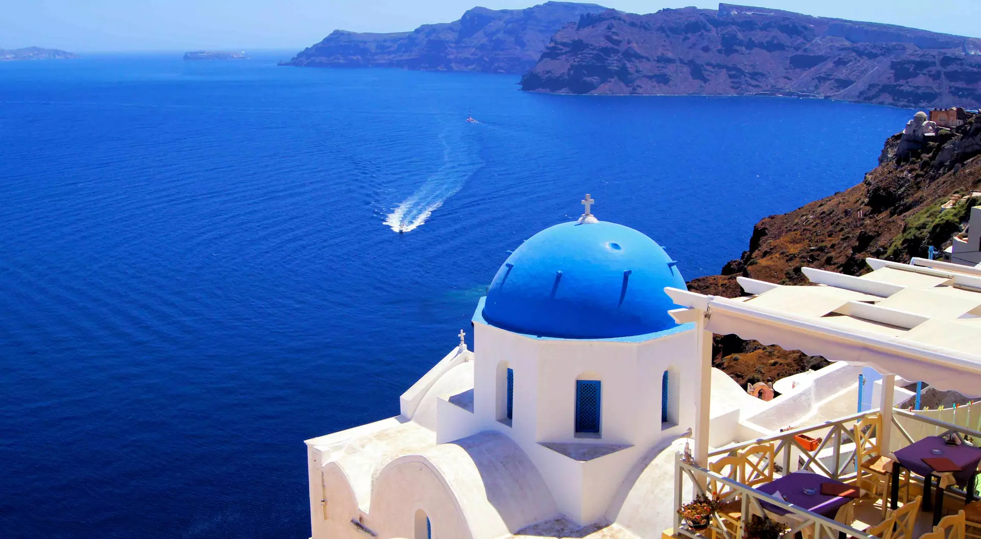 Blue dome church with boat, Oia village, Greece