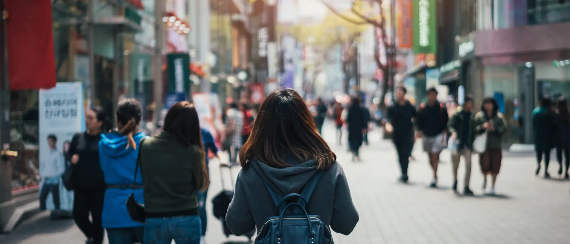 young asian woman walking down a crowded city street