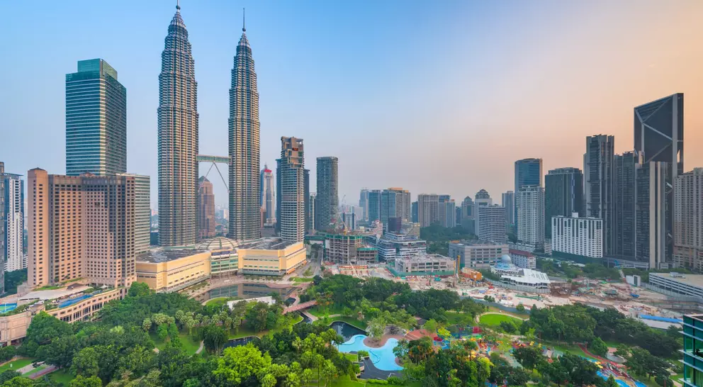 Sunset skyline view of Kuala Lumpur featuring the Petronas Twin Towers, an interlinked pair of 88-storey skyscrapers 
