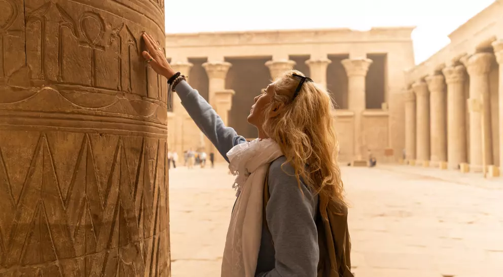 Female tourist touching columns of the temple of Horus in Edfu, Egypt. Esna and Aswan in Egypt.