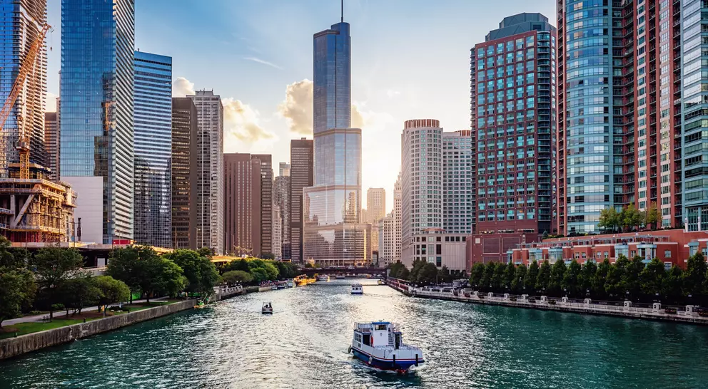 Cityscape from Chicago River Waterfront at Dusk. Small boats and tourist ferries cruising towards the Michigan Lake
