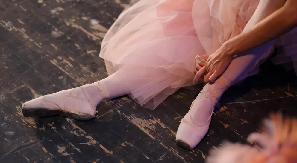 A ballerina in the rehearsal hall of the theater.