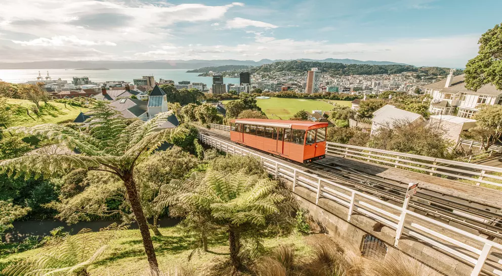 Aerial view over the city of Wellington, New Zealand, with a cable car climbing up the hill in the middle.