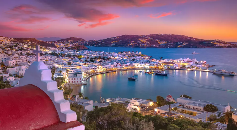 Mykonos port with boats and windmills at evening