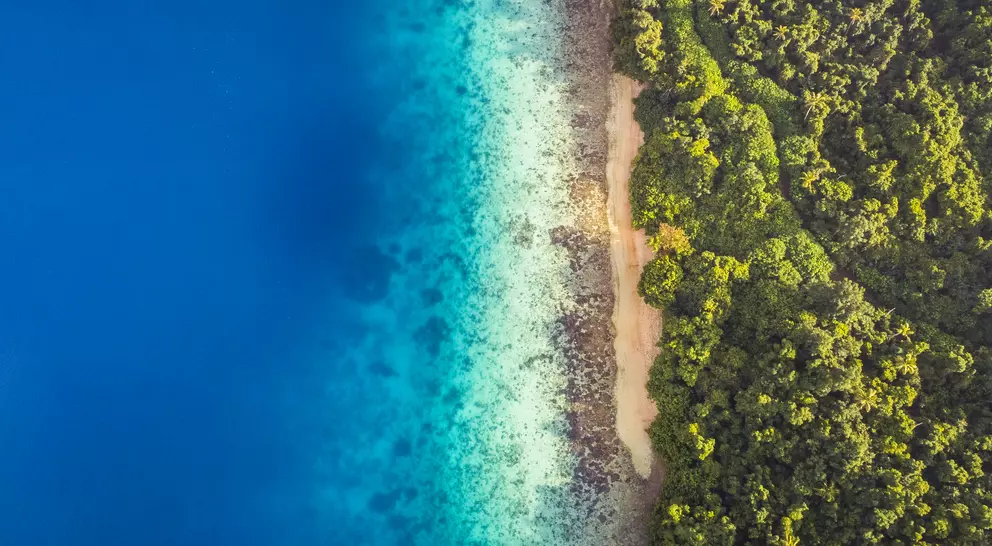 Aerial view of calm aqua marine blue water with tropical secluded beach