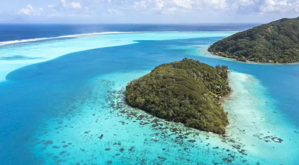 A deep, crystal-clear lagoon surrounds the two islands, while magnificent bays and white-sand beaches add drama