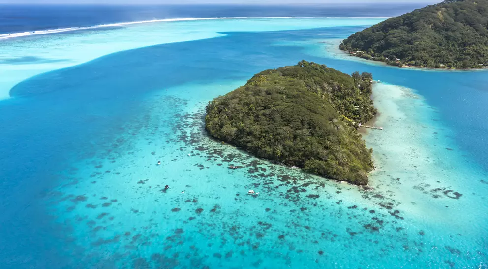 A deep, crystal-clear lagoon surrounds the two islands, while magnificent bays and white-sand beaches add drama