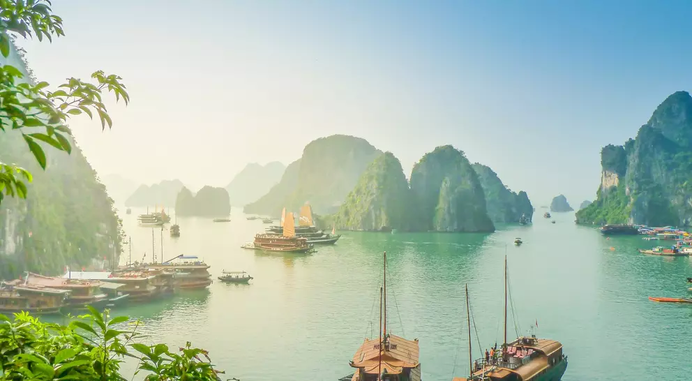 Aerial view of junk boat crusie during sunse near Rock Island, Ha Long Bay, Vietnam. UNESCO World Heritage Site