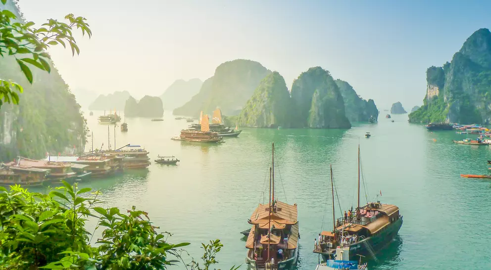 Aerial view of junk boat crusie during sunse near Rock Island, Ha Long Bay, Vietnam. UNESCO World Heritage Site