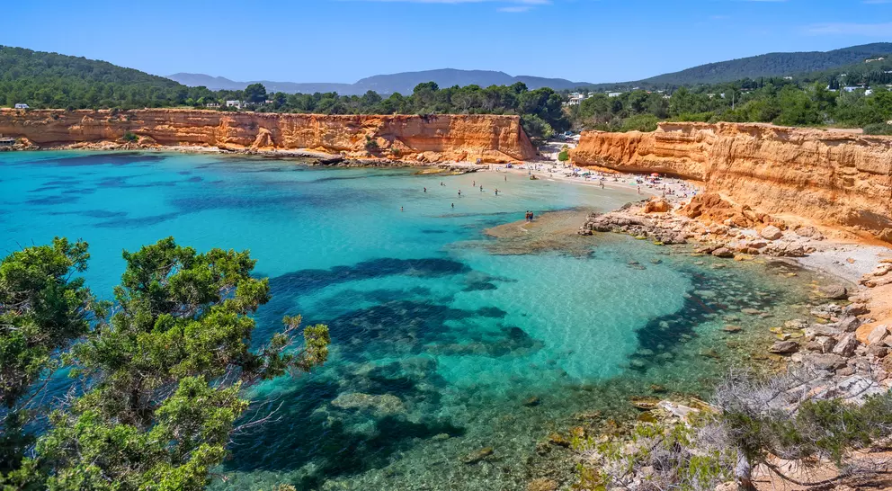 Bright light of a summer noon, transparent waters marbled with Posidonia meadows, sparse bathers on the beach.