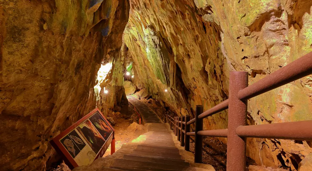 Stairs descend underneath natural rock and caves