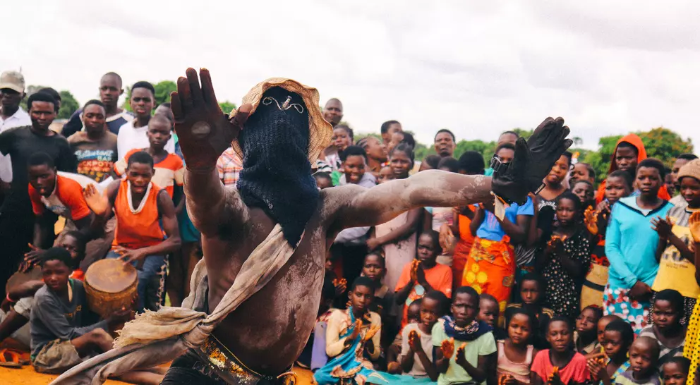 A dancer in traditional attire performs in front of a captivated crowd, showcasing vibrant cultural celebration.