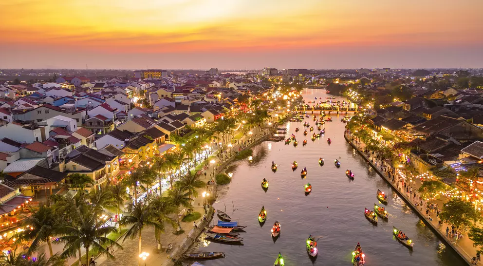 Hoi An at dusk with boats cruising on Thu Bon River with lanterns