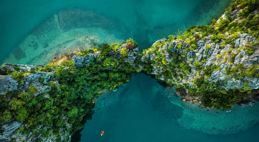 Drone view on rocks and canoes floating on turquoise water