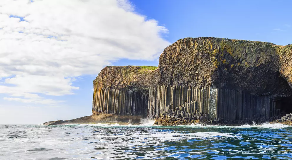 Magnificent rock formations and caves rising from the ocean against cliffside