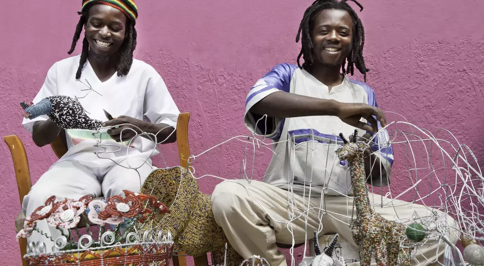 African men working outdoors designing, producing and selling beadwork, directly to the public