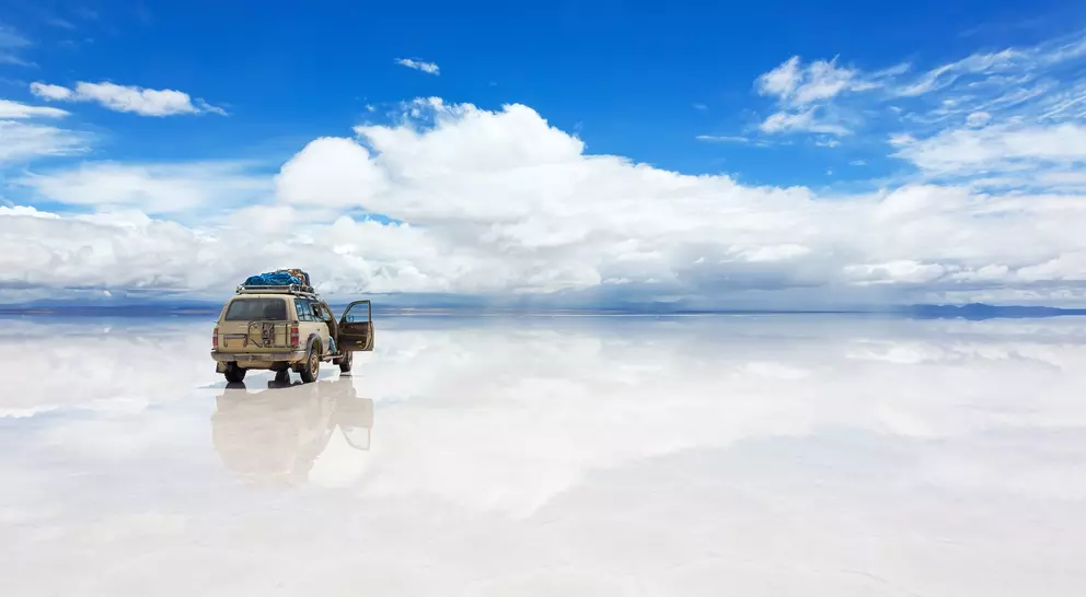 The world's largest salt flat, Salar de Uyuni in Bolivia, with Jeep vehicle driving over