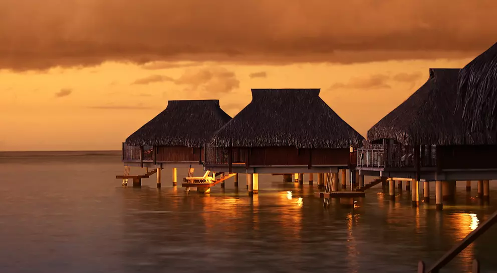 Tropical Tahiti bungalows at sunset