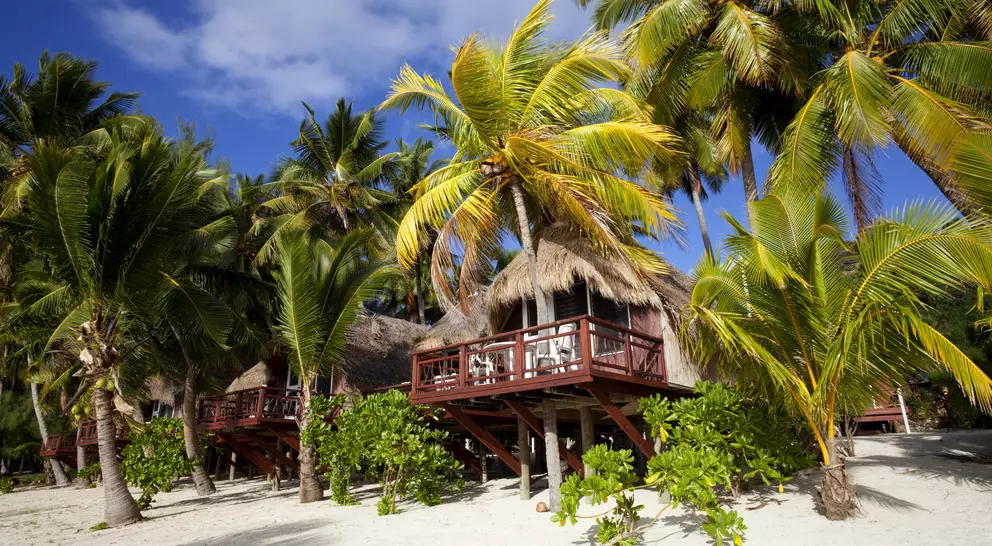 A line of beach huts in Aitutaki, a tropical destination in the Cook Island