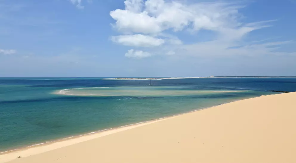 View from a sandune in the Bazaruto archipelago Mozambique with a luxury yacht lying at anchor below. 