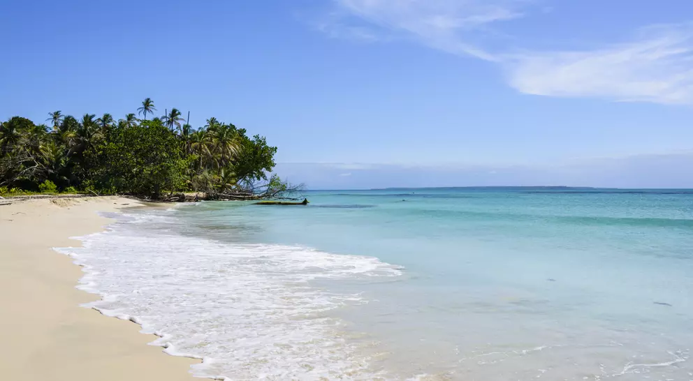 White sand beach on a tropical island surrounded by a turquoise sea.
