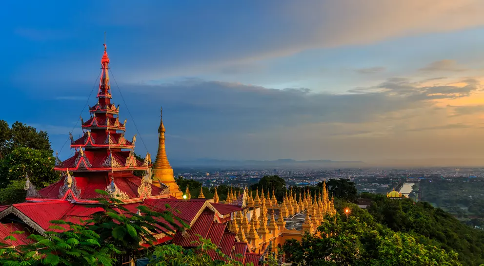 HIllside view of the red roof of Mandalay Palace and Hill