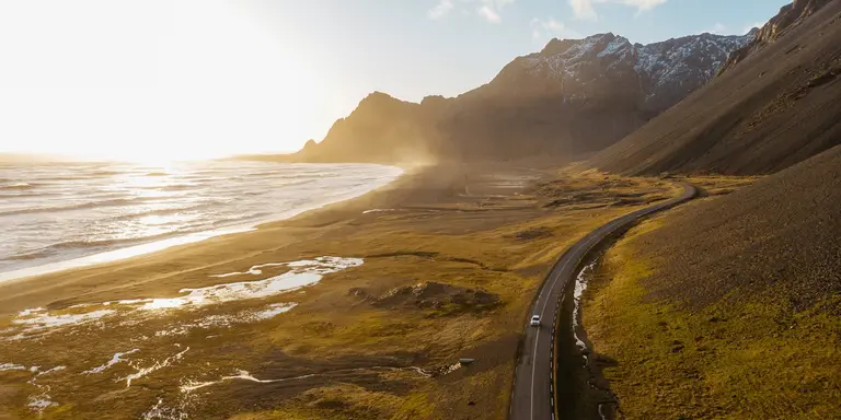 Aerial view of a car driving on scenic road in Iceland