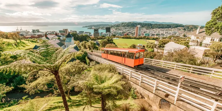 Aerial view over the city of Wellington, New Zealand, with a cable car climbing up the hill in the middle.
