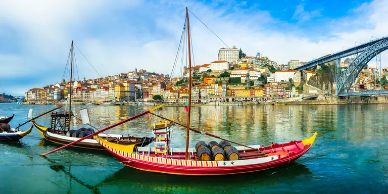 Panorama of beautiful Porto with traditional boats on the river