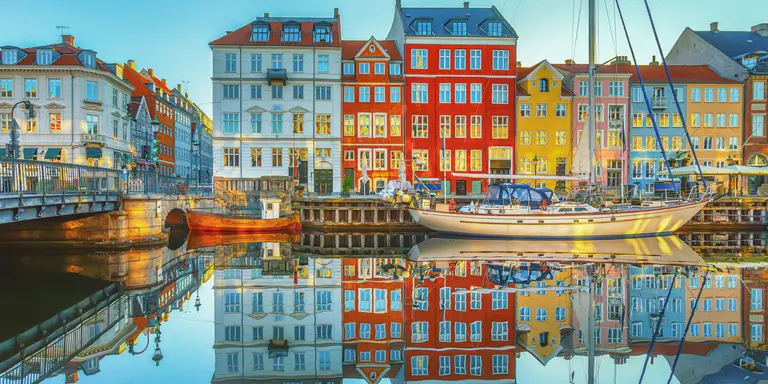 View of clear waters reflecting the buildings of Nyhavn along the canals of Copenhagen, Denmark