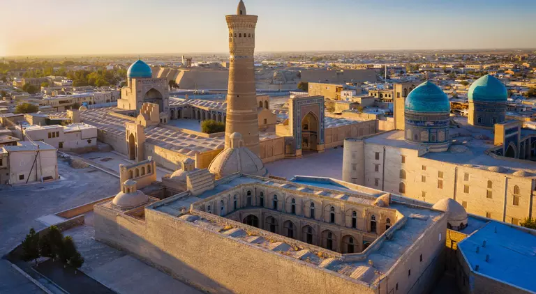 Sunset over the famous Kalyan Poi Kalon Minaret, Poi Kalan or Po-i-Kalyan and Mir Arab Madrasah in the center of the old town of Bukhara