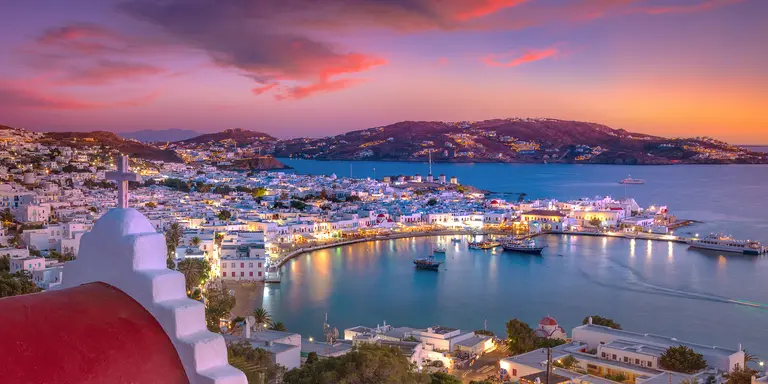 Mykonos port with boats and windmills at evening