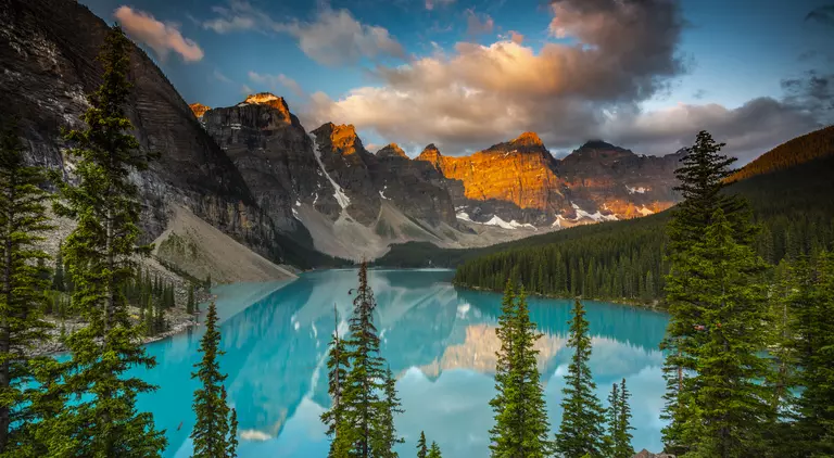 Moraine Lake in Banff National Park at sunset. Mountains of famous Ten Peaks reflecting in the beautiful calm turquoise water of the lake