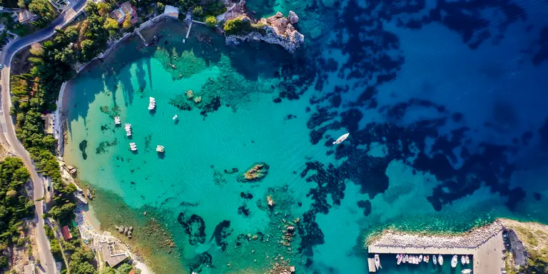 Aerial view of the coastline shot from the air, showing deep blue colours of the Mediterranean Sea.
