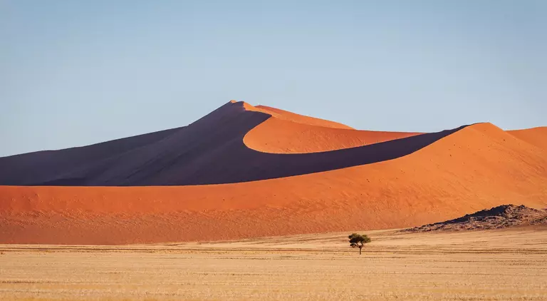 Warm late afternoon light close to sunset shining over the majestic Namibian Desert Sand Dunes