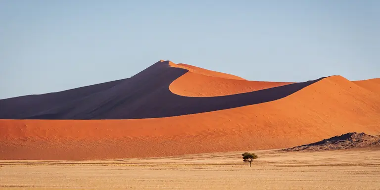 Warm late afternoon light close to sunset shining over the majestic Namibian Desert Sand Dunes