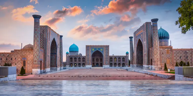 Samarkand Registan Square with Sher-Dor, Ulugh Beg and Tilya-Kori Madrasahs under colorful moody sunset twilight cloudscape