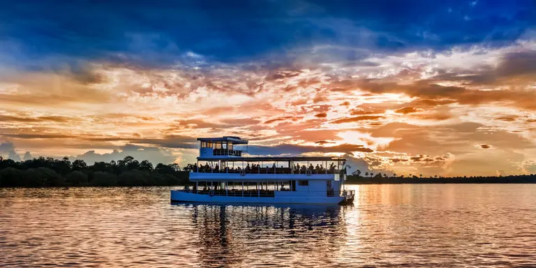 Picturesque sunset landscape with the riverboat at Zambezi river