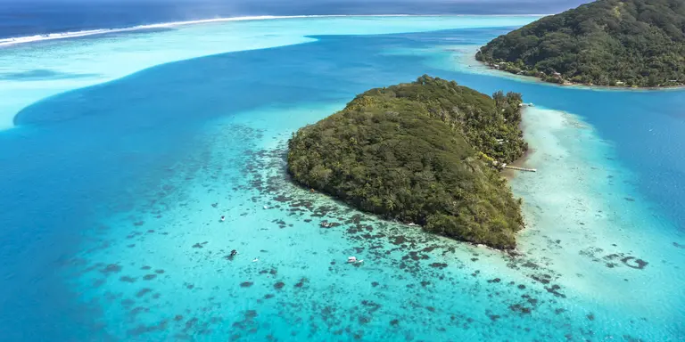 A deep, crystal-clear lagoon surrounds the two islands, while magnificent bays and white-sand beaches add drama