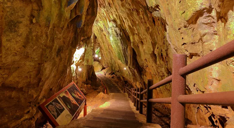 Stairs descend underneath natural rock and caves