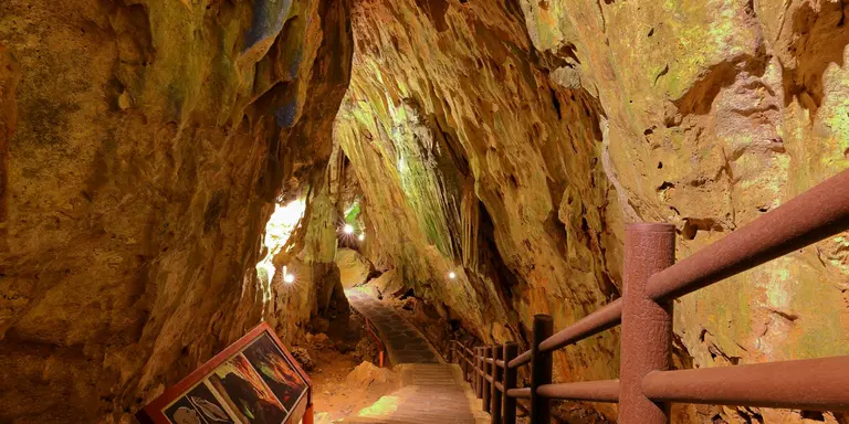 Stairs descend underneath natural rock and caves