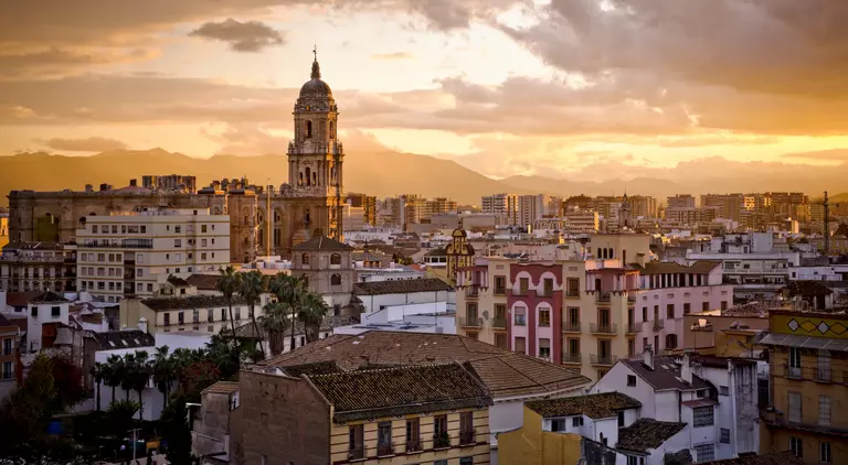 Sunset over city skyline and distant mountains