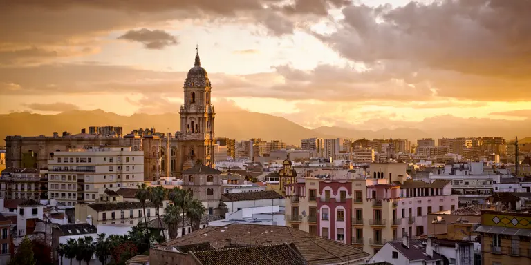 Sunset over city skyline and distant mountains
