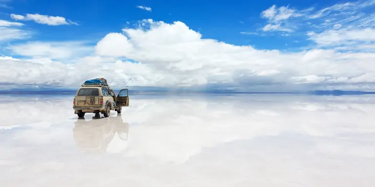 The world's largest salt flat, Salar de Uyuni in Bolivia, with Jeep vehicle driving over