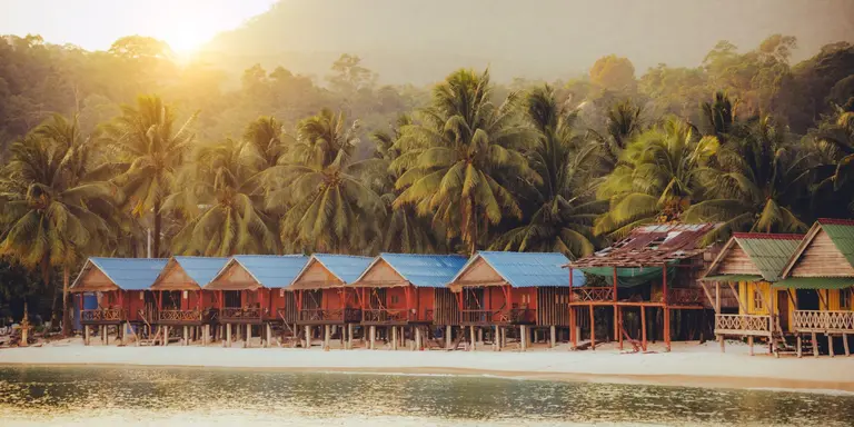 Elevated bungalows along beach with lush palm trees on the secluded Island Koh Rong Sanloem, Sihanoukville Province, Cambodia