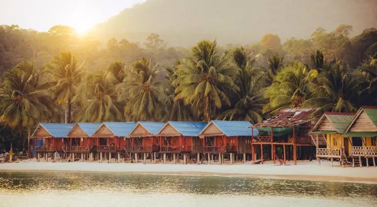Elevated bungalows along beach with lush palm trees on the secluded Island Koh Rong Sanloem, Sihanoukville Province, Cambodia