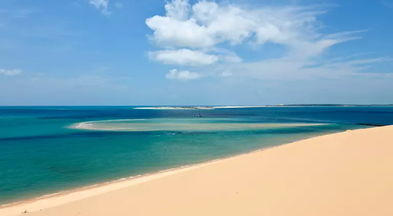 View from a sandune in the Bazaruto archipelago Mozambique with a luxury yacht lying at anchor below. 