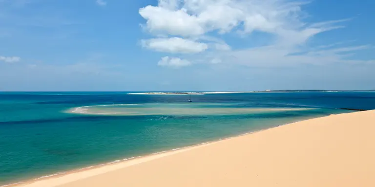 View from a sandune in the Bazaruto archipelago Mozambique with a luxury yacht lying at anchor below. 