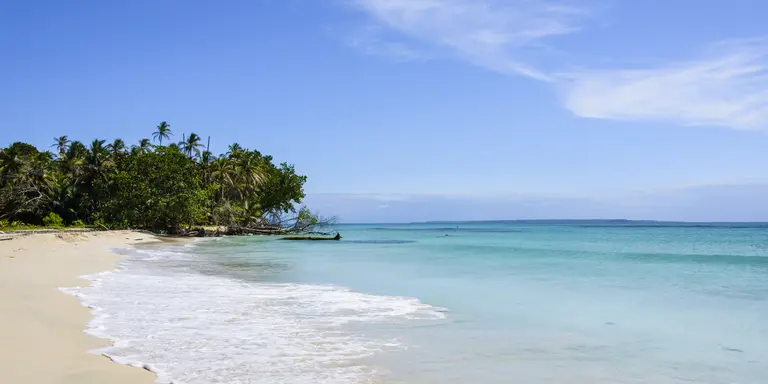 White sand beach on a tropical island surrounded by a turquoise sea.
